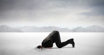 Businessman burying his head in the sand